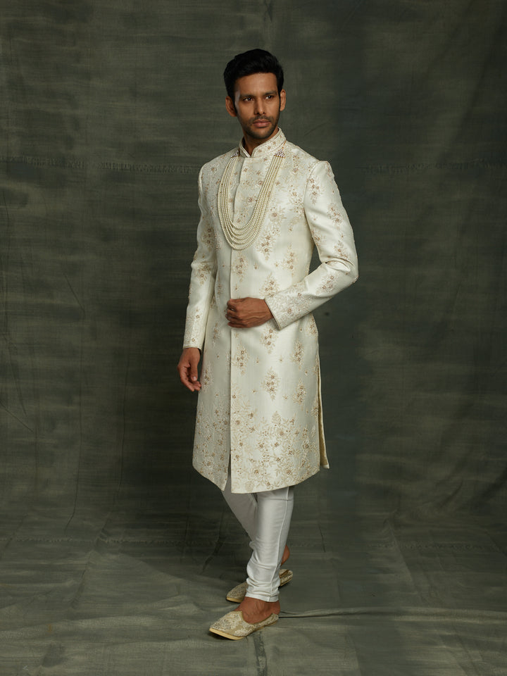 Off-white silk sherwani with floral work placement.