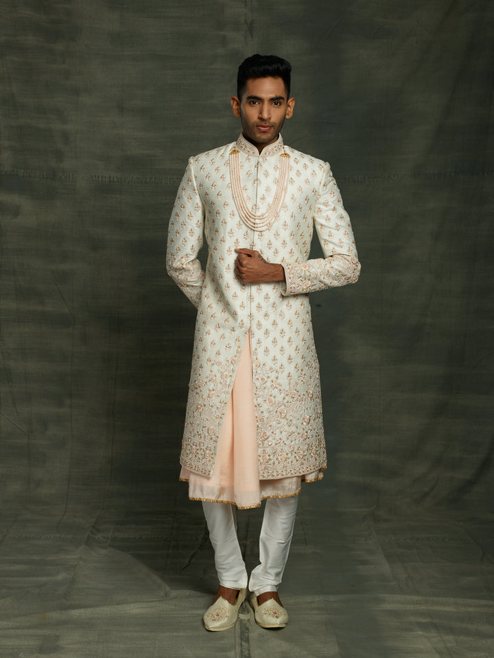 Off-white sherwani with floral motif.