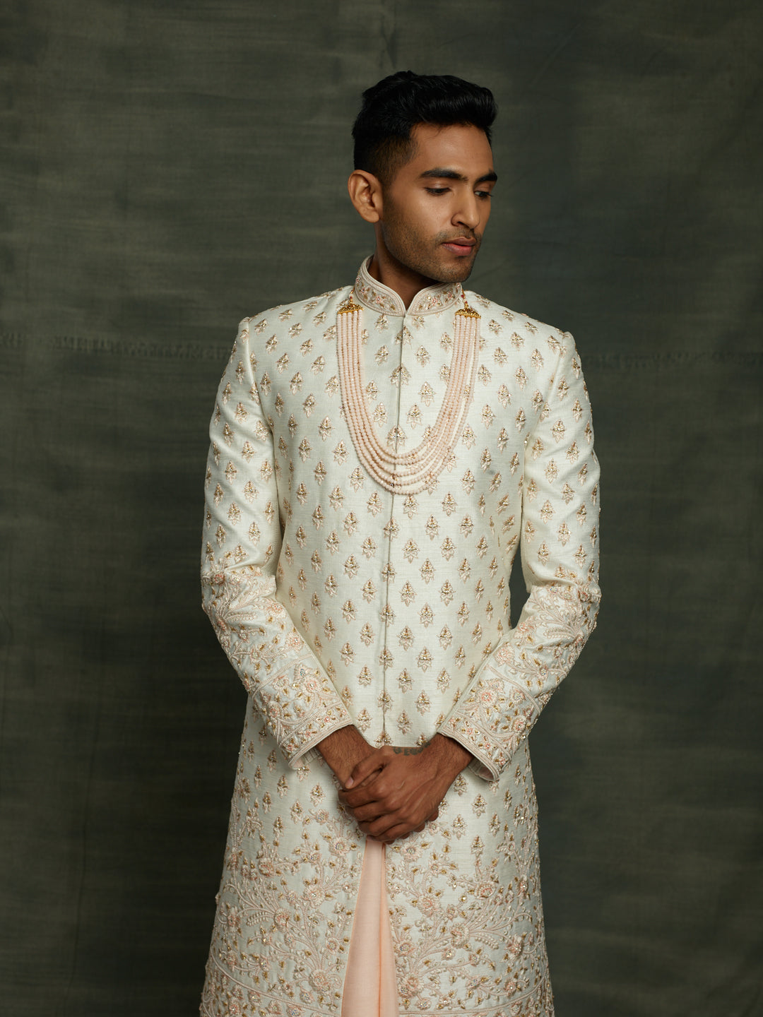 Off-white sherwani with floral motif.