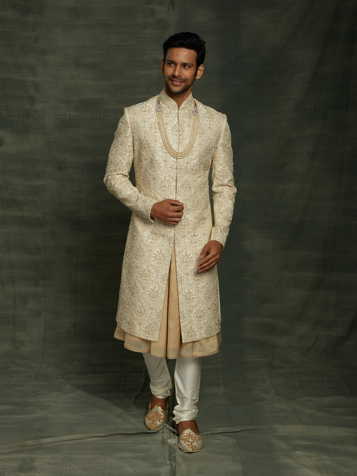 Cream sherwani with self embroidery.