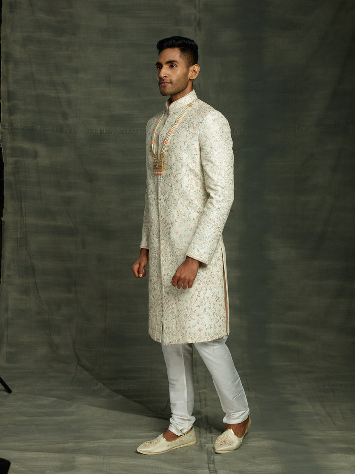 Off-white silk sherwani with peach highlights.