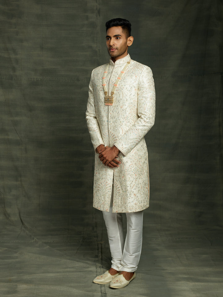 Off-white silk sherwani with peach highlights.