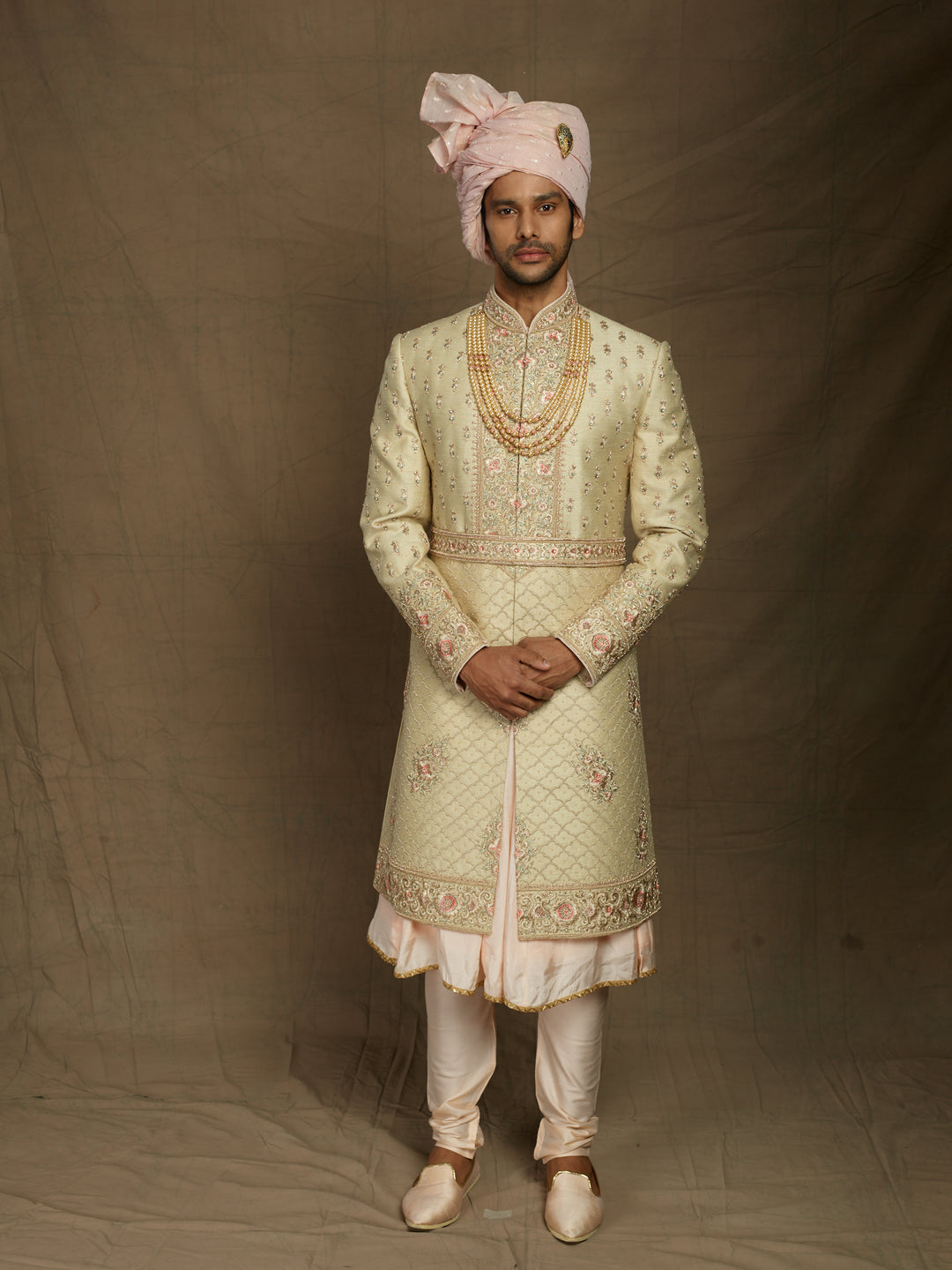 Cream sherwani with peacock feather motifs