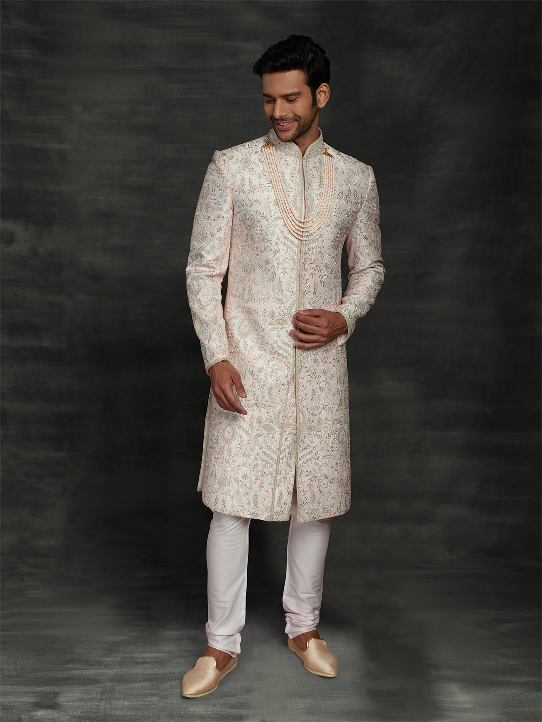 Overall embroidered sherwani in powder pink color.