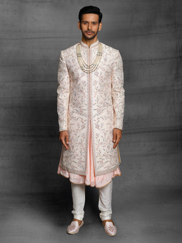 Peach groomswear sherwani with minimal blue highlights.