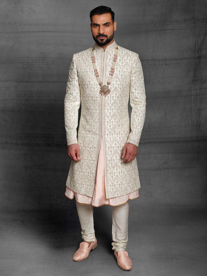 Ivory sherwani with geometric work placement.