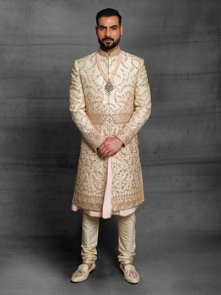 Gold sherwani with peach combination for groom.