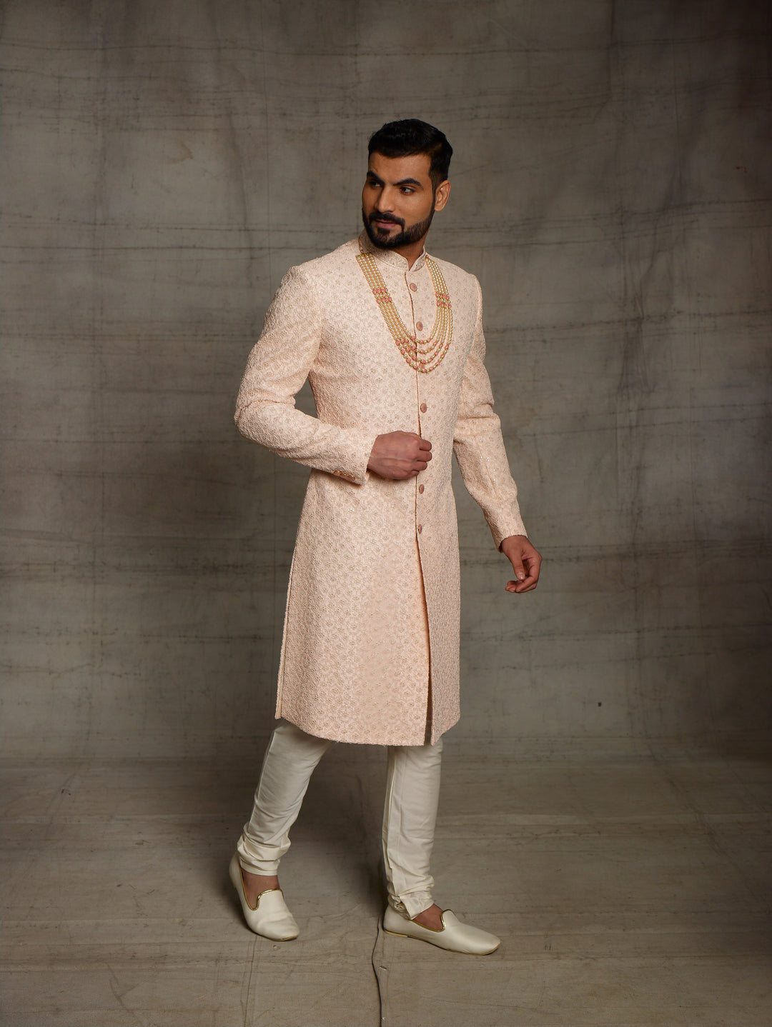 Net fabric based sherwani in peach color.