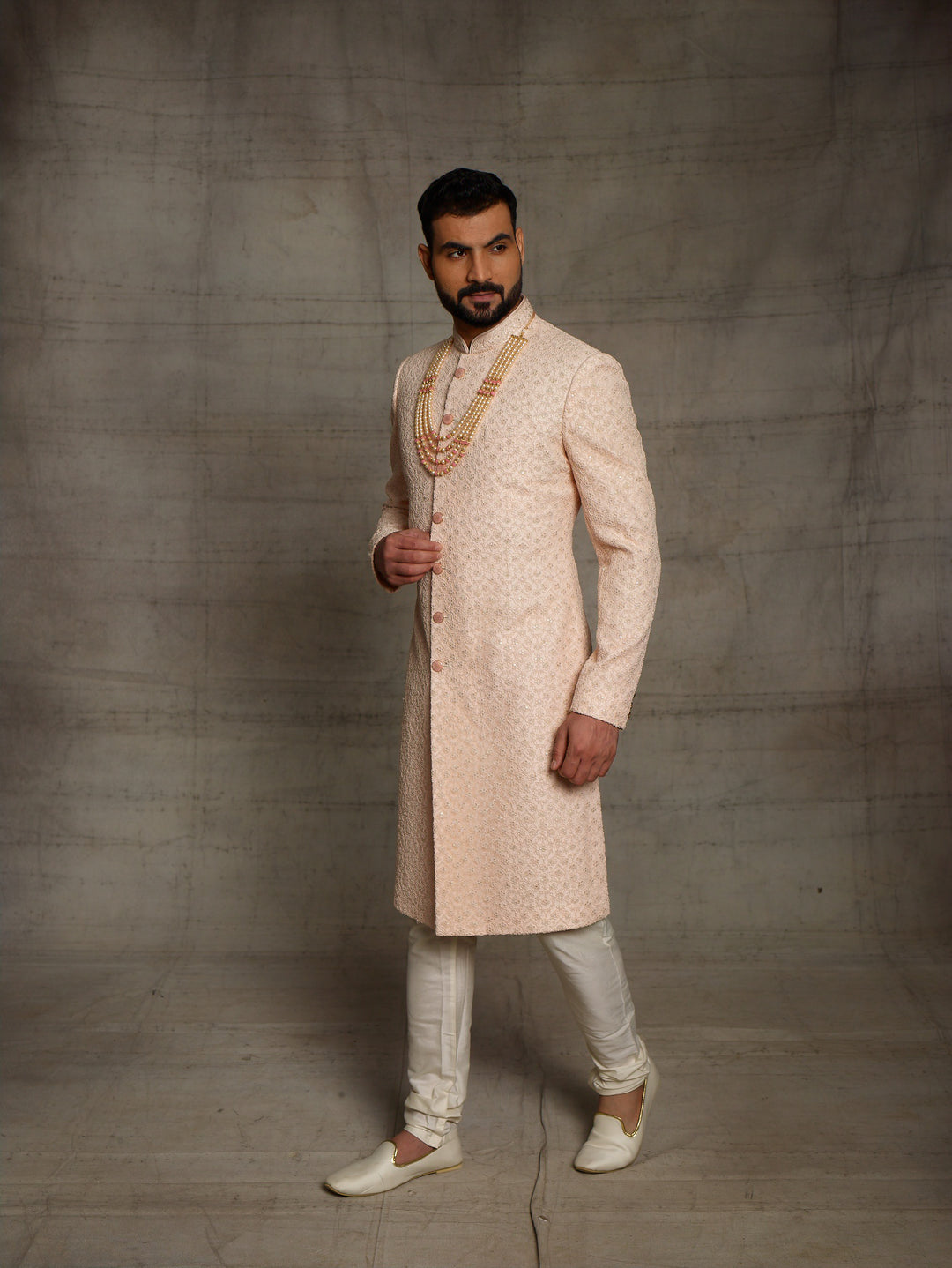 Net fabric based sherwani in peach color.