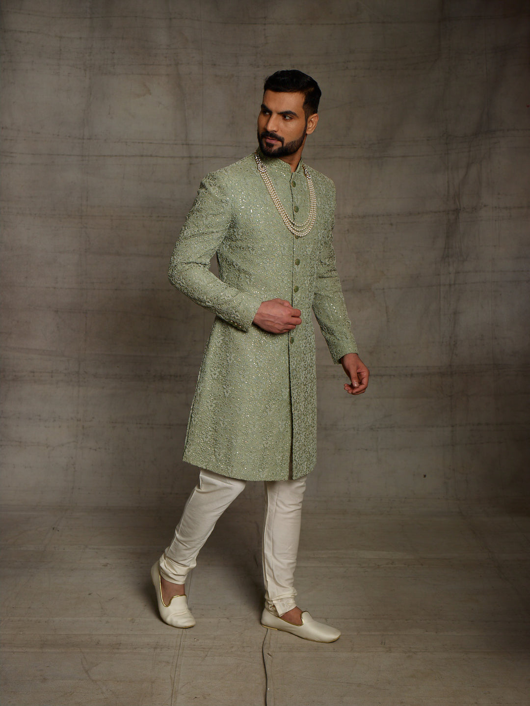 Simple net sherwani in green color.