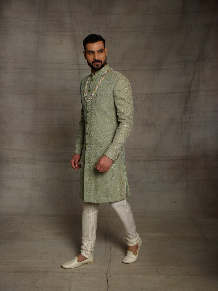 Simple net sherwani in green color.