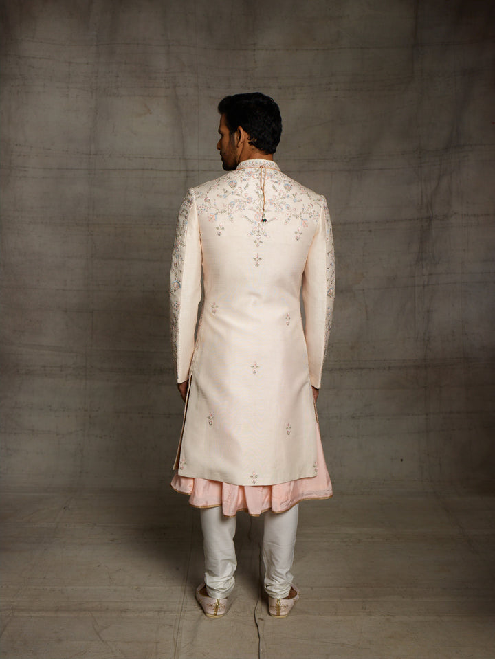 Peach groomswear sherwani with minimal blue highlights.