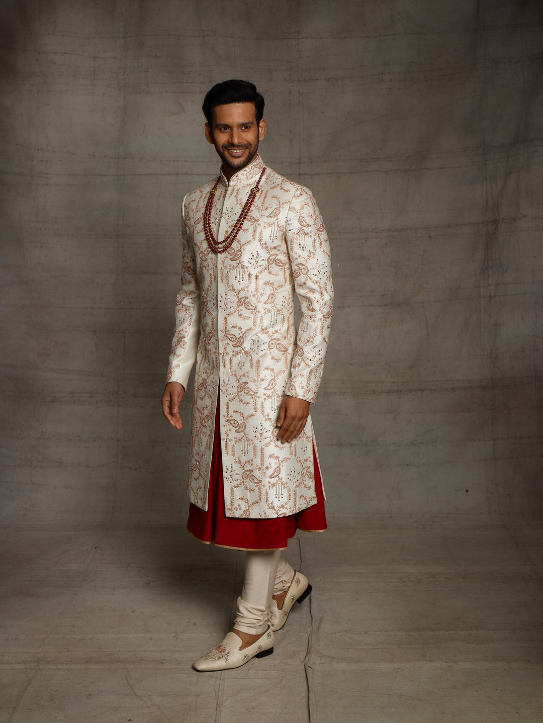 Classic white-maroon combination sherwani with overall jaal work.