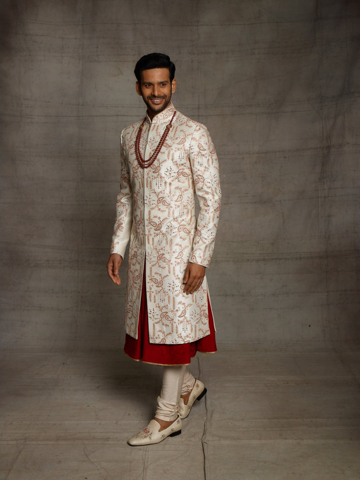 Classic white-maroon combination sherwani with overall jaal work.