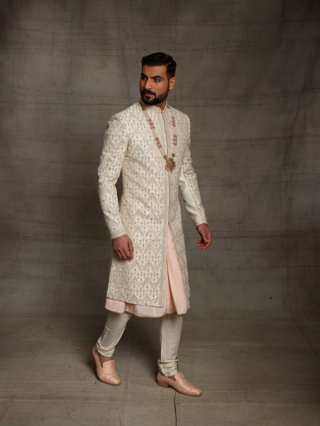 Ivory sherwani with geometric work placement.