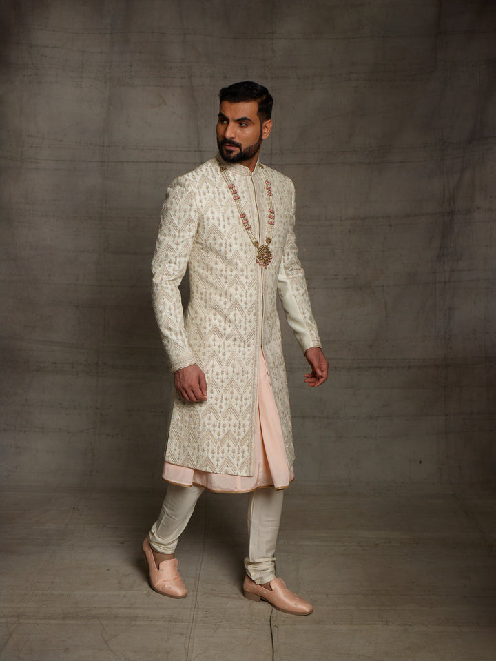 Ivory sherwani with geometric work placement.