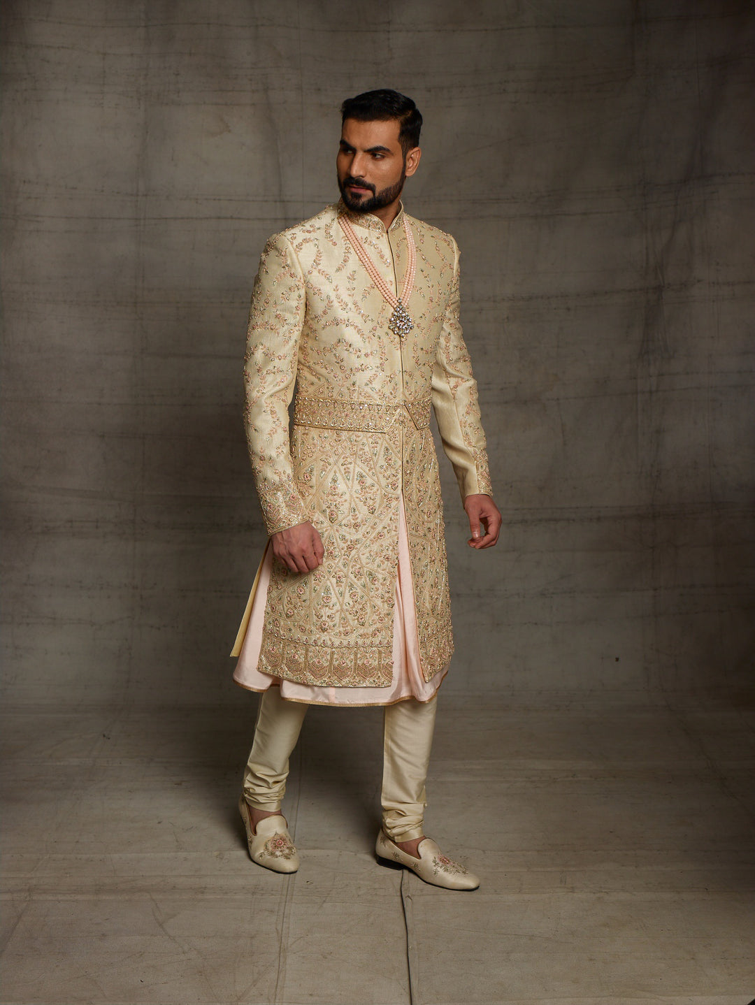 Gold sherwani with peach combination for groom.