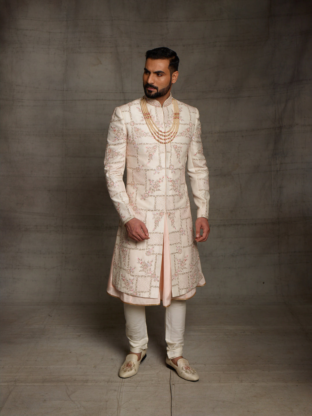 Light peach grooms wear sherwani with geometric design.