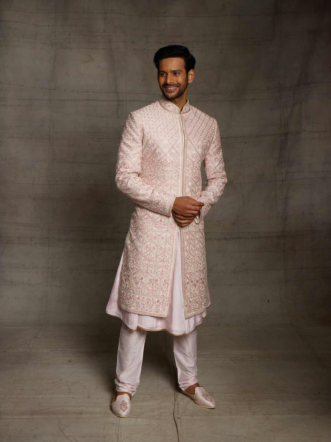 Powder pink sherwani with overall resham embroidery.