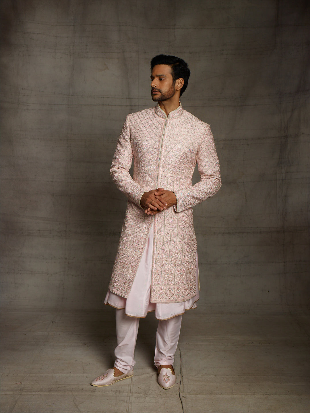 Powder pink sherwani with overall resham embroidery.