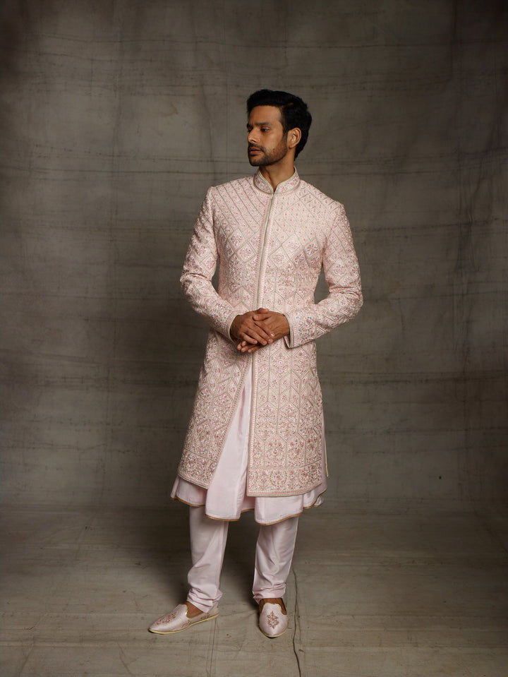 Powder pink sherwani with overall resham embroidery.