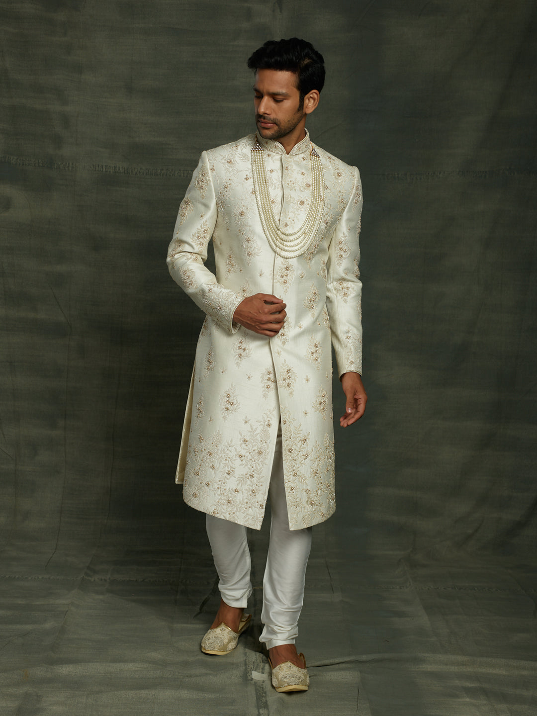 Off-white silk sherwani with floral work placement.