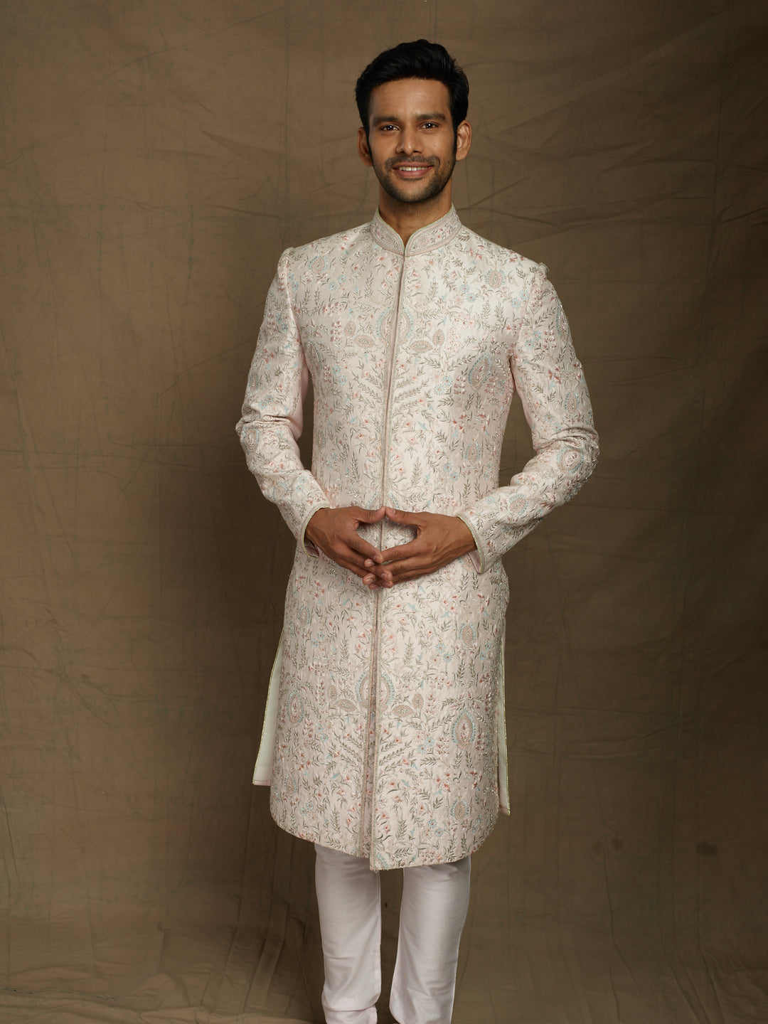 Overall embroidered sherwani in powder pink color.