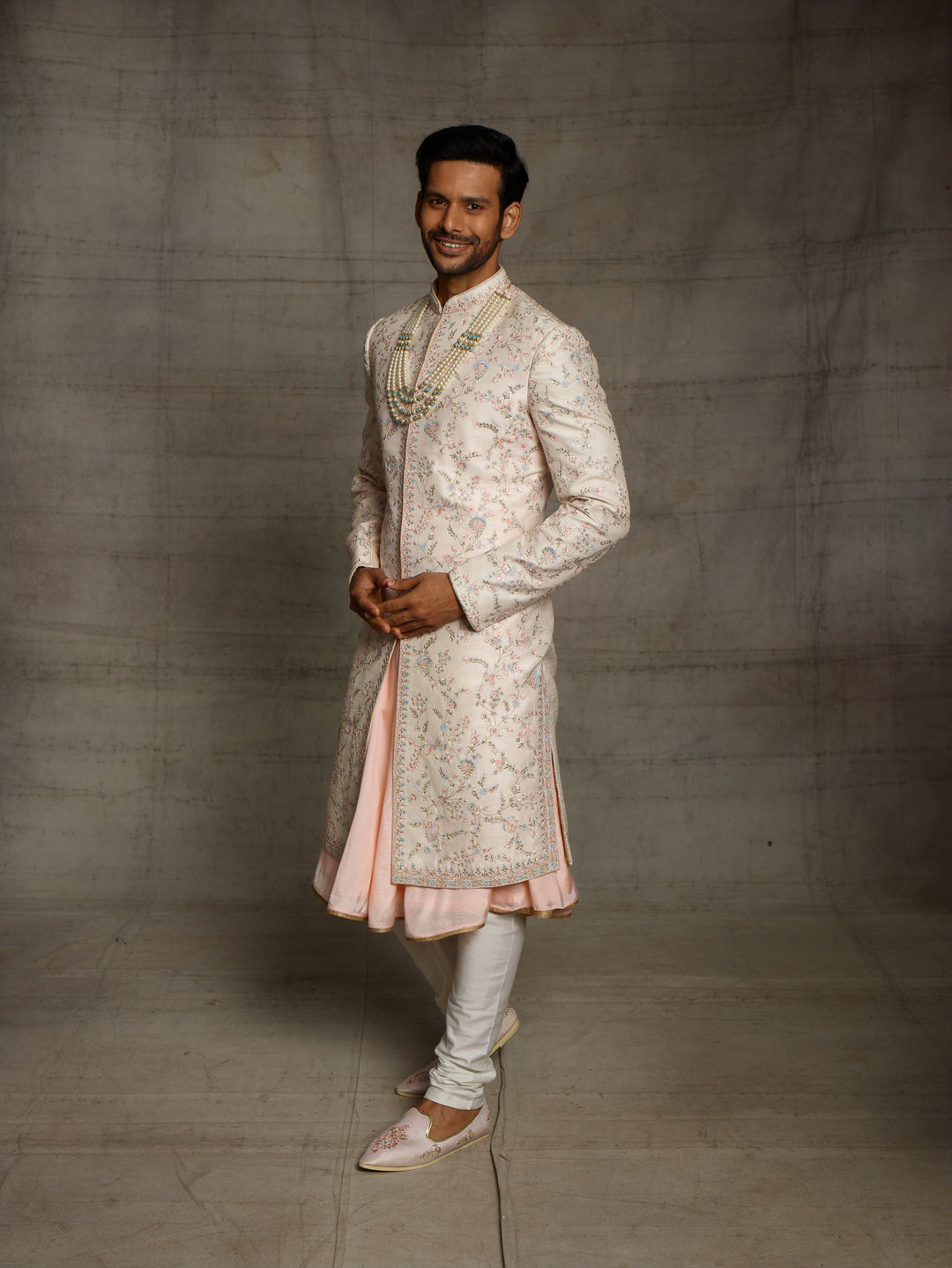 Peach groomswear sherwani with minimal blue highlights.