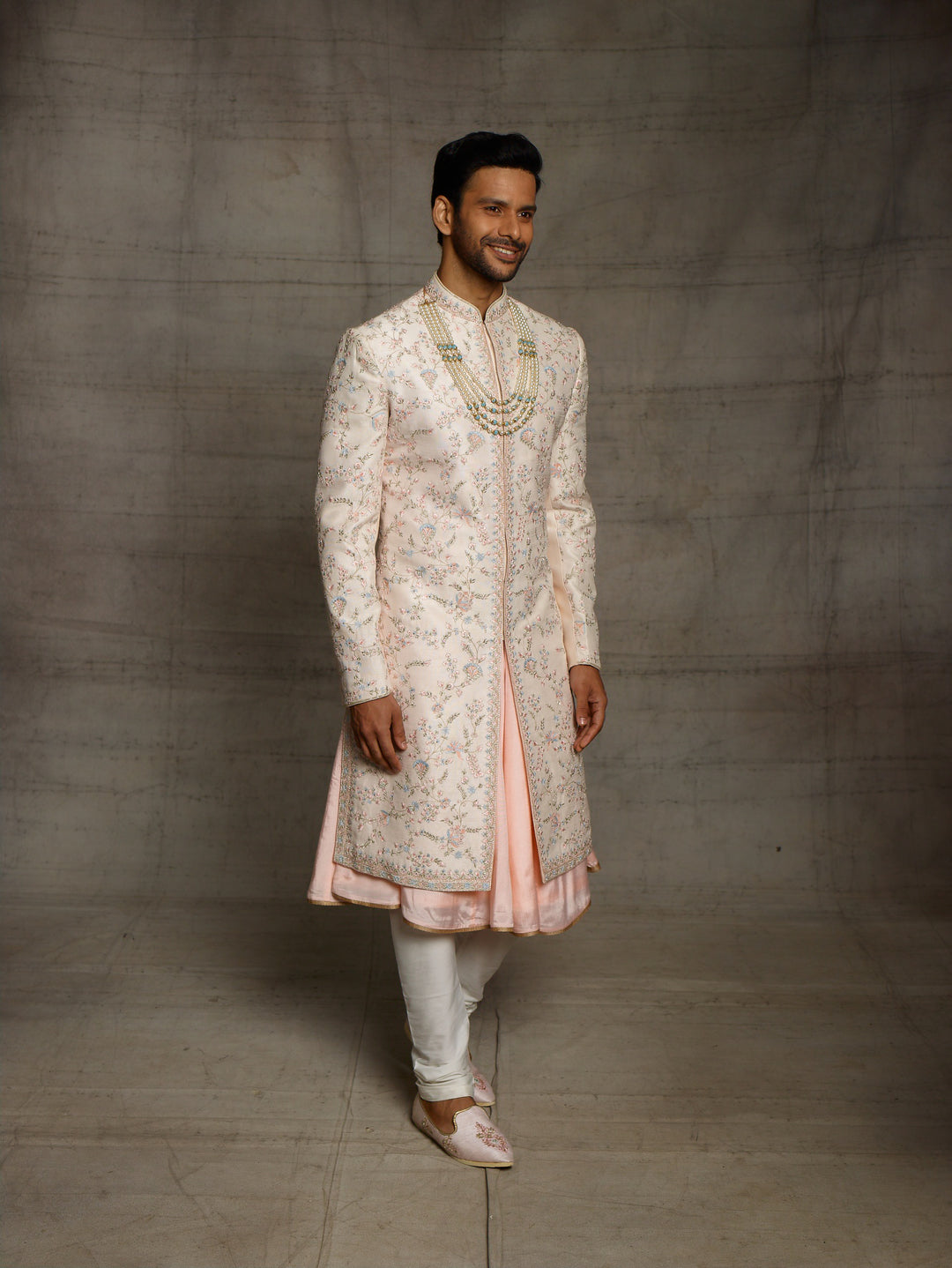 Peach groomswear sherwani with minimal blue highlights.