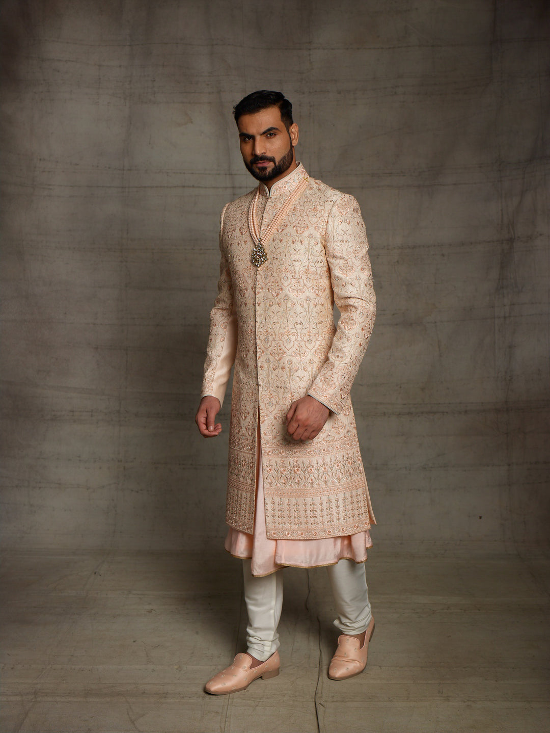 Peach sherwani with metallic rose gold resham embroidery.