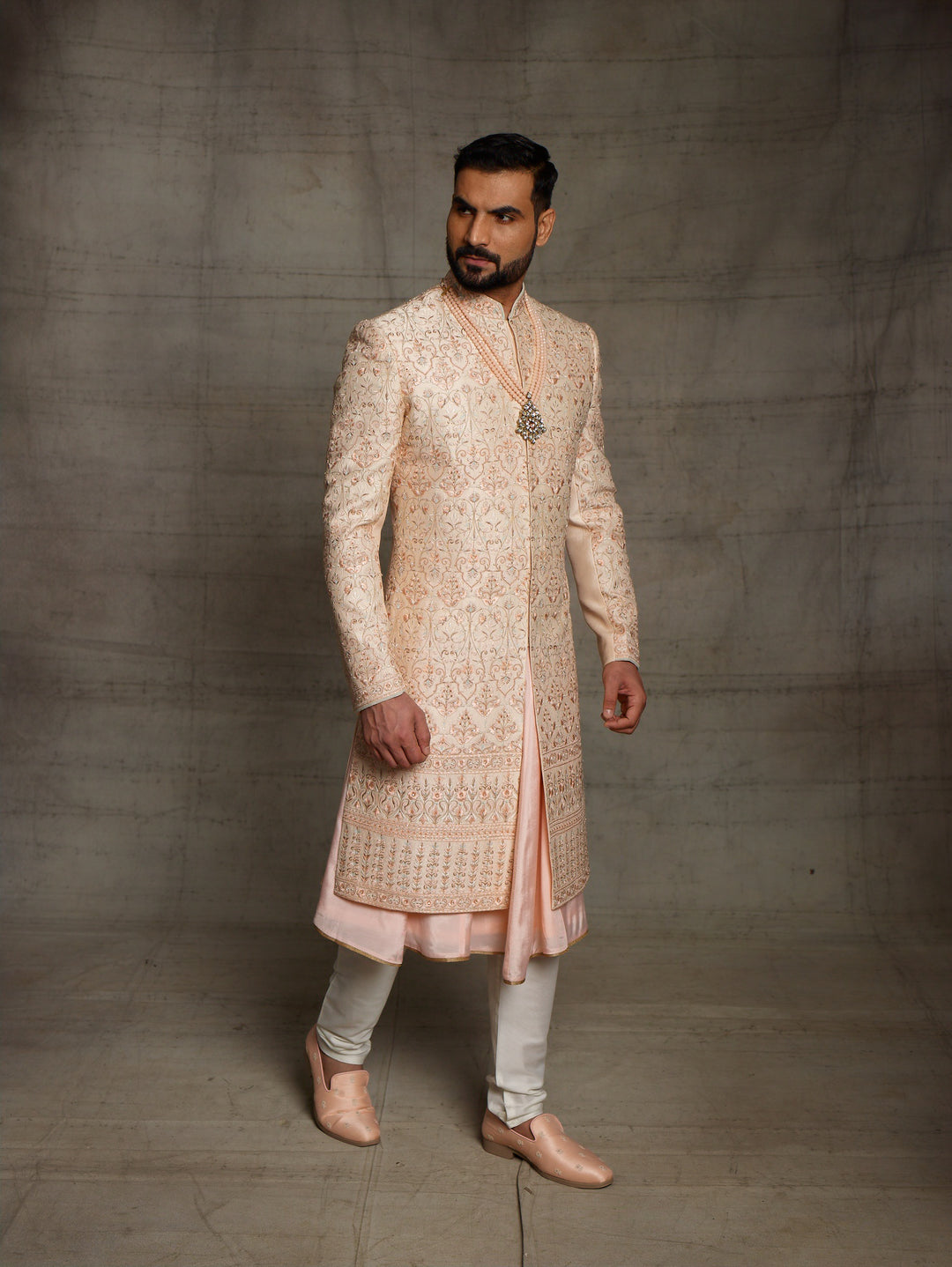 Peach sherwani with metallic rose gold resham embroidery.