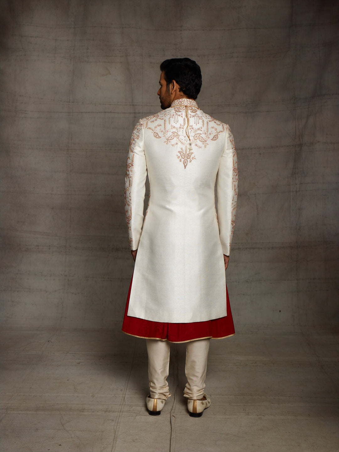 Classic white-maroon combination sherwani with overall jaal work.