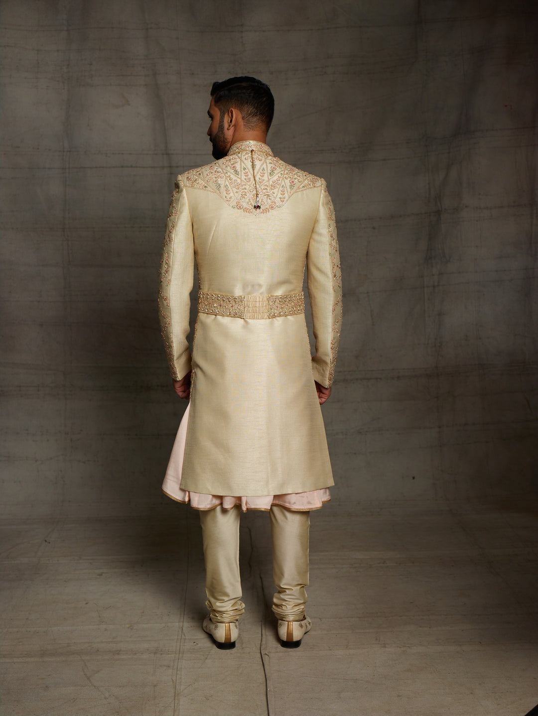 Gold sherwani with peach combination for groom.