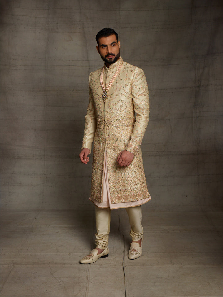 Gold sherwani with peach combination for groom.