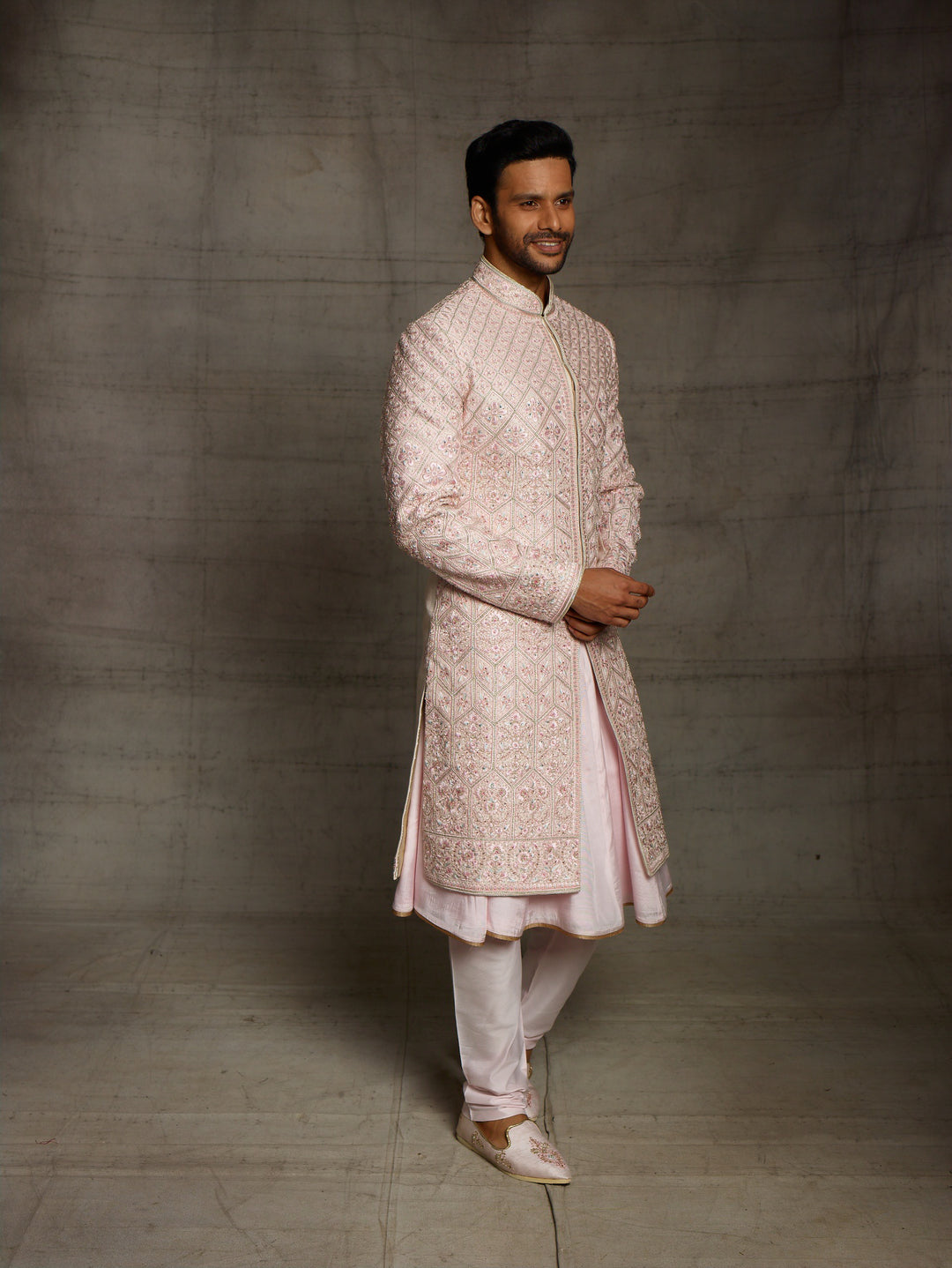 Powder pink sherwani with overall resham embroidery.