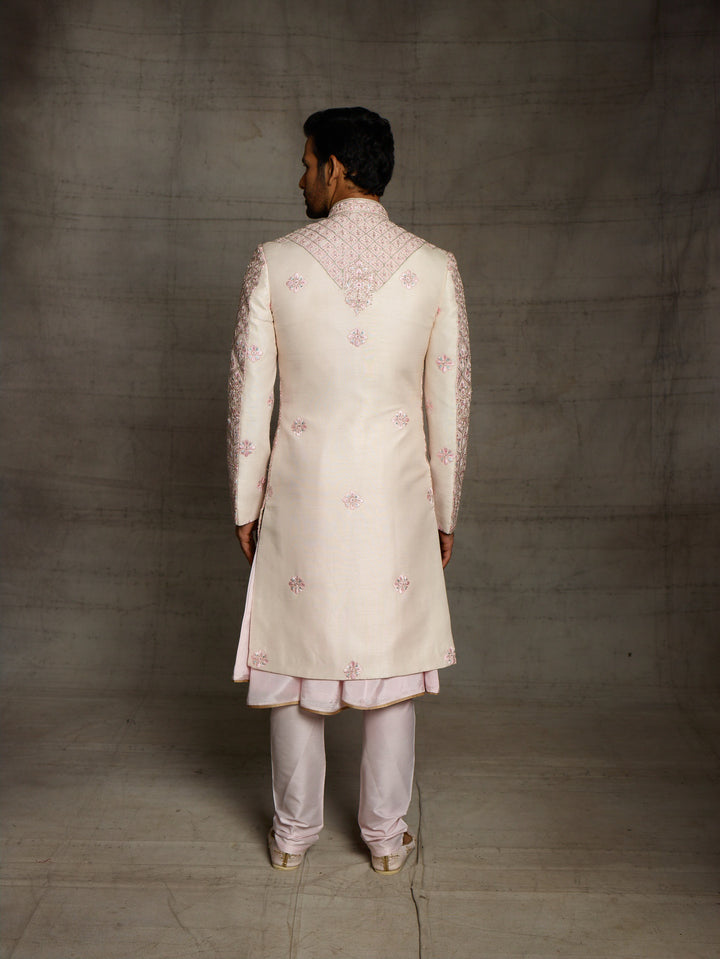 Powder pink sherwani with overall resham embroidery.